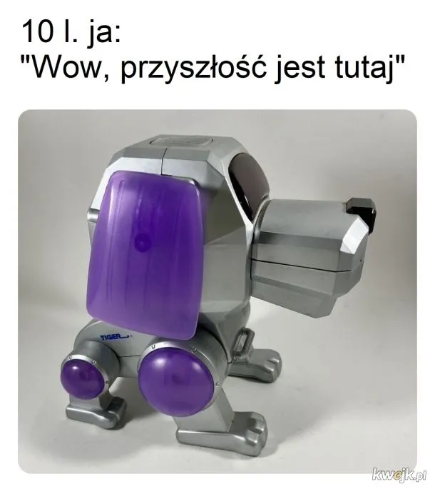 Zabawka robot-pies z napisem "10 l. ja: 'Wow, przyszłość jest tutaj'", przedstawiający nostalgiczne elektroniczne zwierzątko z lat 90.